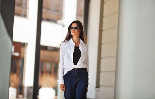 a chic woman in a button down white shirt tied at the waist