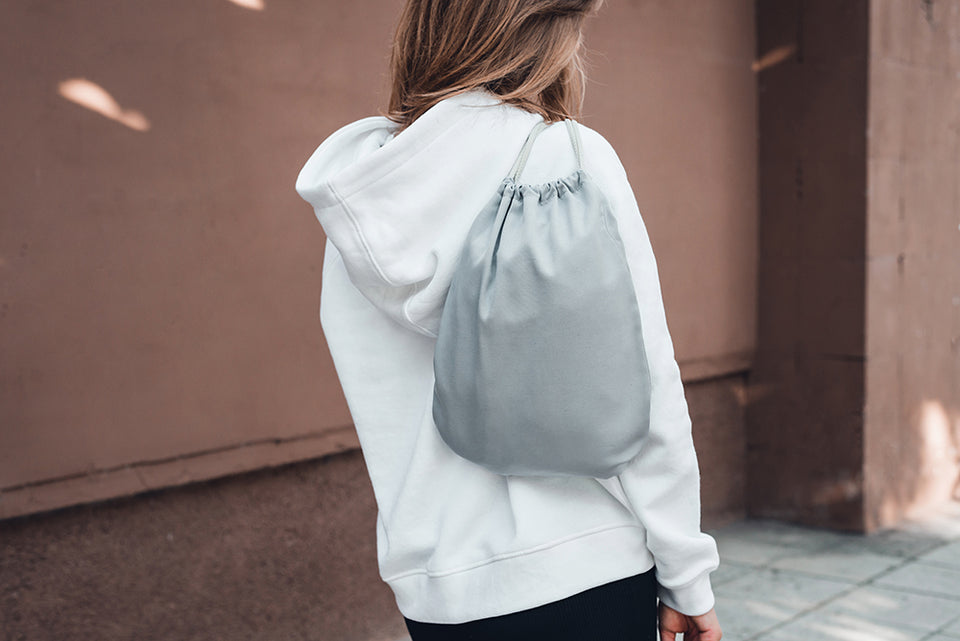a silver grey satin dust bag worn over the shoulder