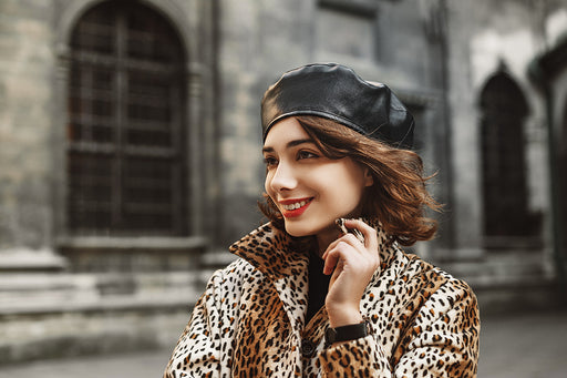 a woman wearing a leopard print faux fur coat with a black leather beret