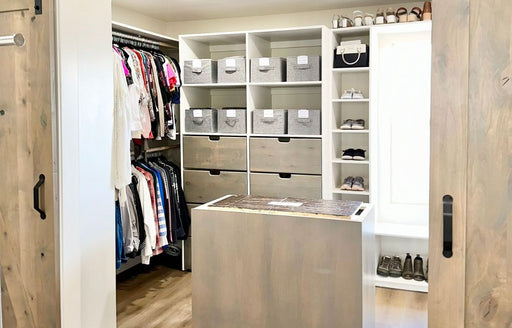 an interior view of a well organized walk-in master closet, arranged by Riquel’s company @R.Organize