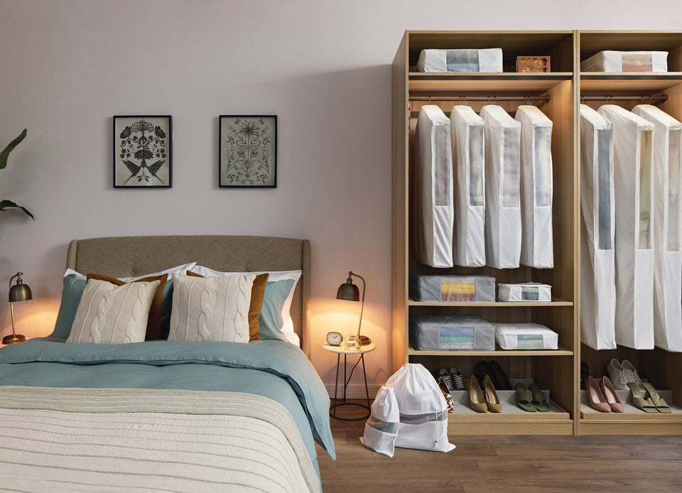 a collection of Hayden Hill storage bags, dust bags, and hanging bags in a bedroom