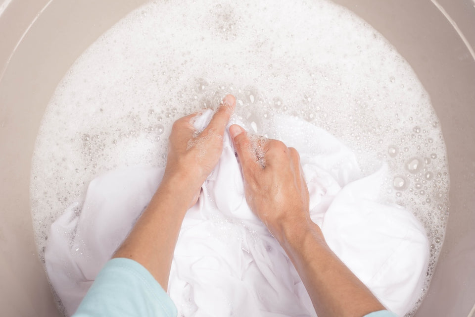 a close up of a woman washing white garments