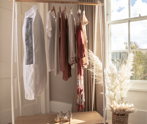 Organized clothes in a Hayden Hill organic cotton storage bag on a hanging rail