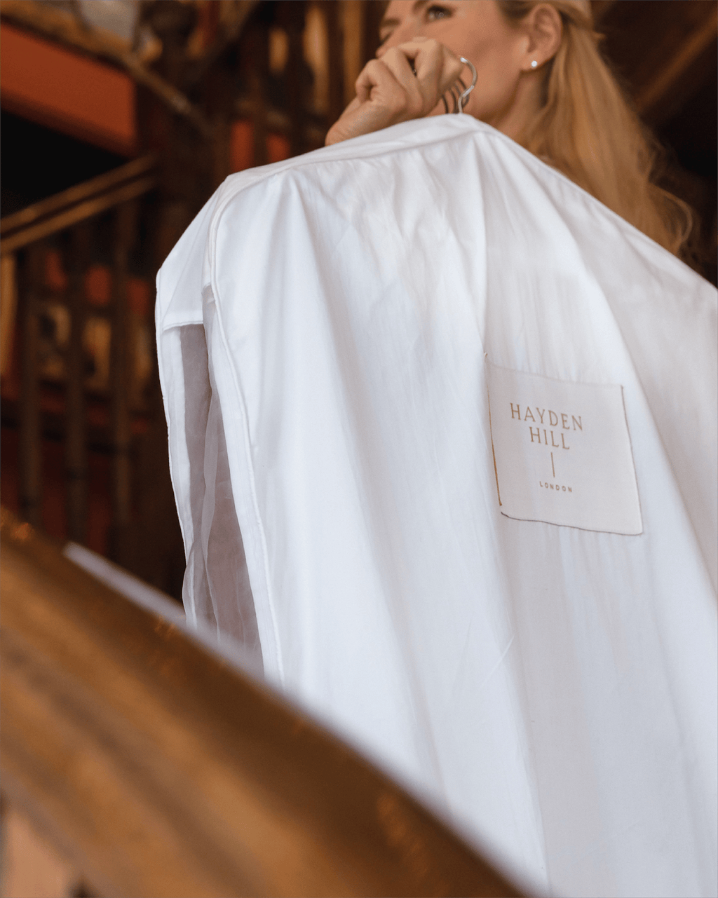 a woman carrying an organic cotton hanging bag on a hanger over her shoulder