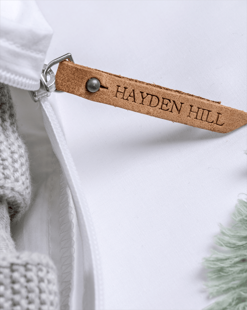 a close up of the leather Hayden Hill zipper pull on a storage bag