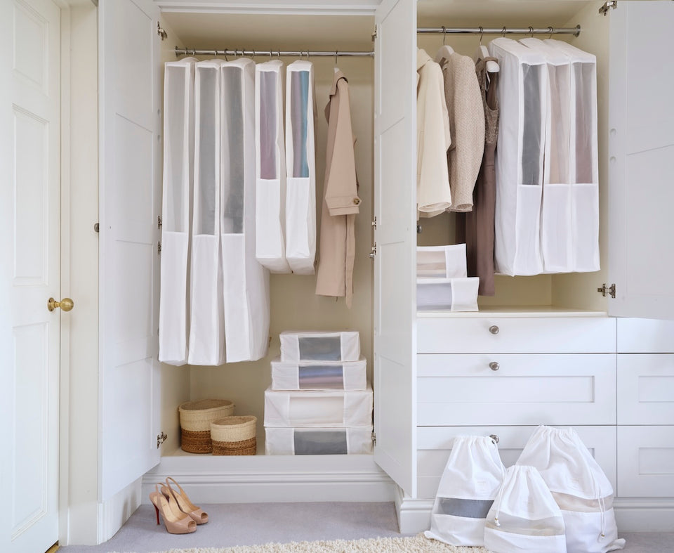 an open closet filled with the Hayden Hill Complete Collection in White,comprising of Long and Short Hanging Bags, Large, Extra Large and Double Extra Large Storage Bags and Small, Medium and Large Dust Bags
