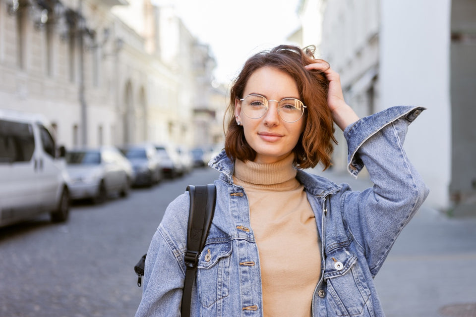 a woman wearing a roll neck and a denim jacket walking about town