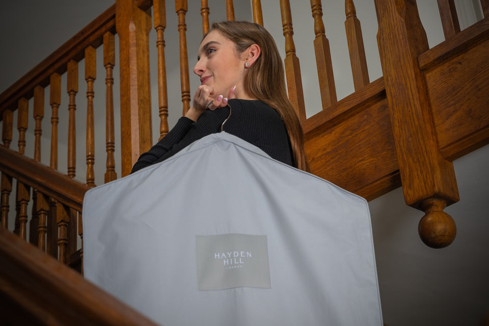 a woman standing on a staircase carrying a gray Hayden Hill organic hanging bag