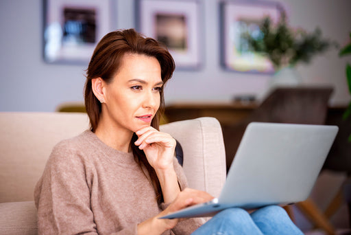 a stylish woman at home searching online with her laptop