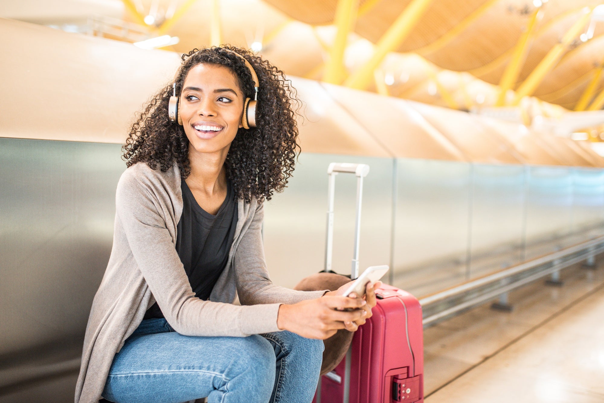 beautiful woman sitting at the airport with a luggage