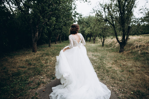 a bride in a flowing white gown walking outdoors