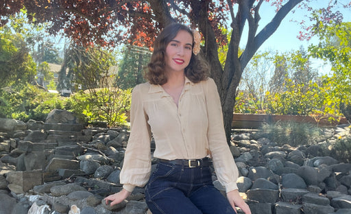 Marley wearing a 1940’s inspired outfit pairing a cream shirt with a front yoke and dark blue denim jeans