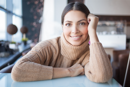 a smiling beautiful woman wearing a soft cashmere roll neck sweater