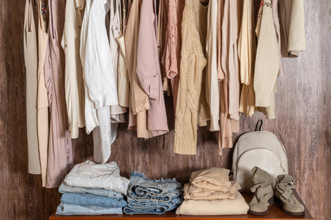 a closet full of hanging and folded clothing