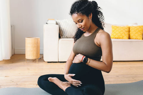 a pregnant woman in her active wear rubbing her belly