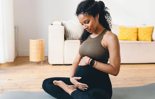 a pregnant woman in her active wear rubbing her belly