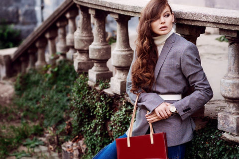 a stylish woman wearing a white belt over a large gray blazer