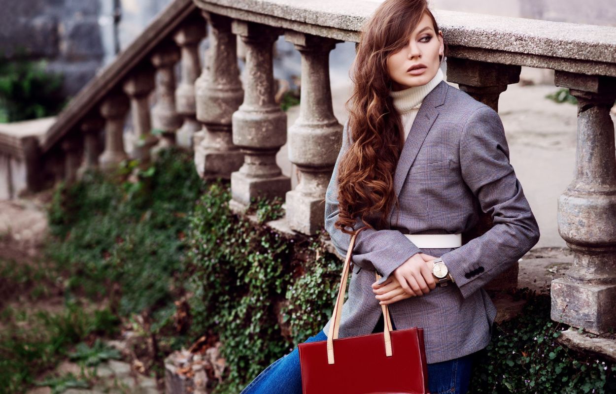 a stylish woman wearing a white belt over a large gray blazer