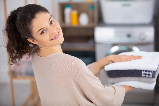 a woman holding a stack of towels