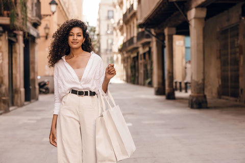 a woman wearing a white shirt and camisole tucked into a pair of cream high waisted pants and belt