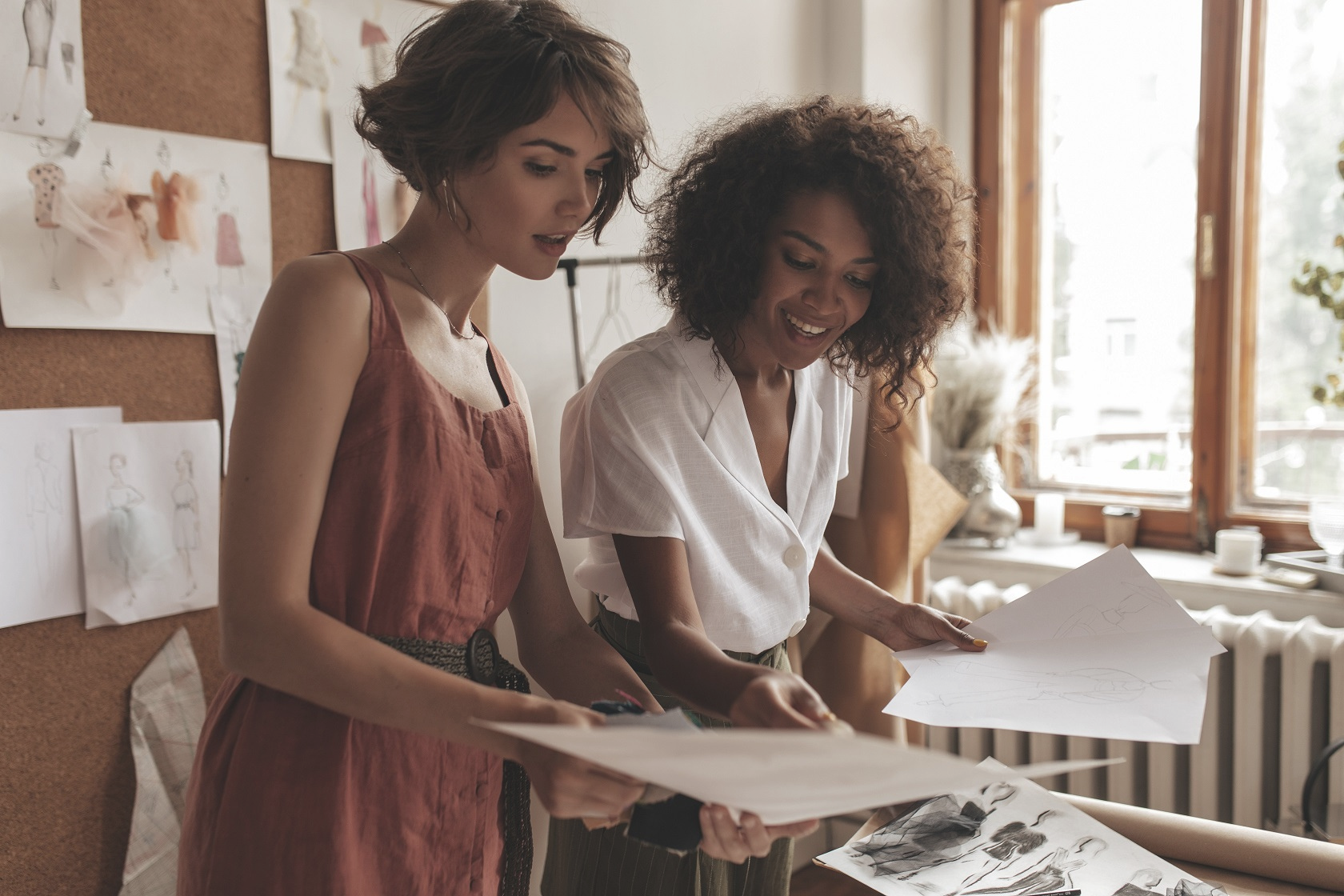 two women wearing linen clothing discussing fashion designs