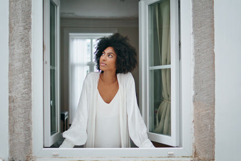 a woman looking out of the window of her home