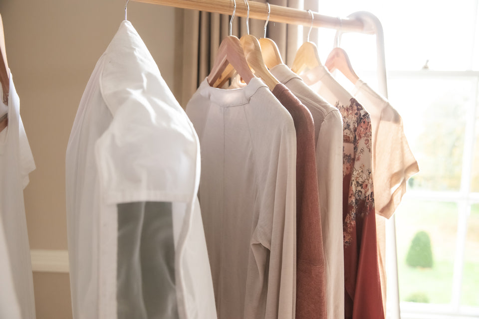 a selection of clothes on wooden hangers