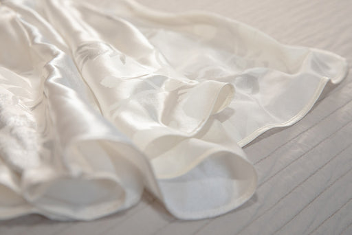 the edge of an ivory-colored silk skirt