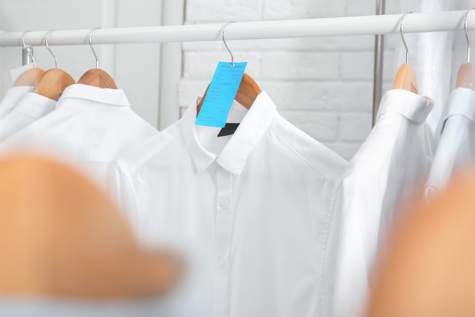 a white shirt with a dry cleaning ticket on a hanger