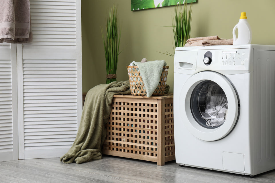 the corner of a  laundry room with a washing machine