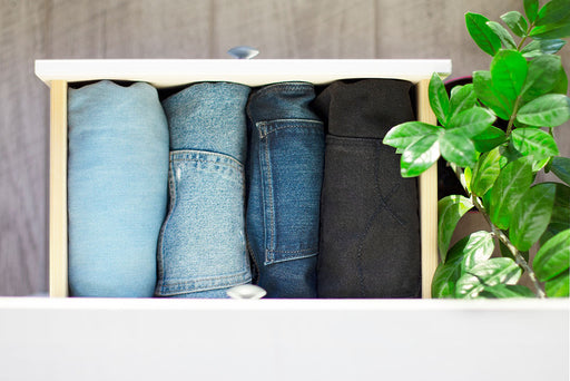 an assortment of denim jeans vertically stored in a drawer