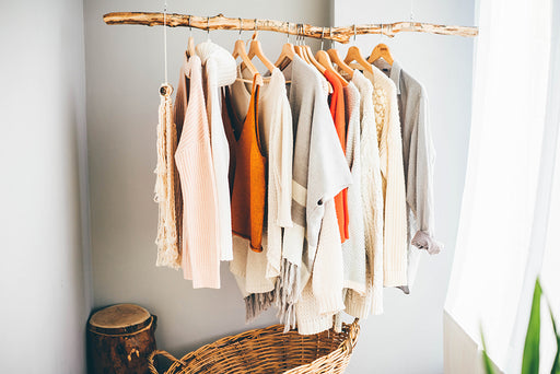 a selection of coordinated clothing hanging on a wooden rail