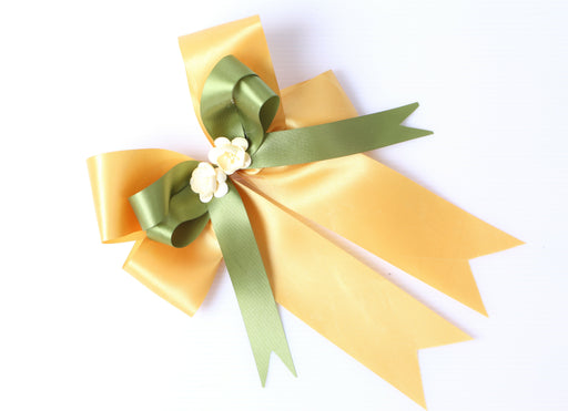 a golden and green satin gift bow