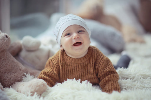 a happy baby wearing a cashmere blend ribbed pullover