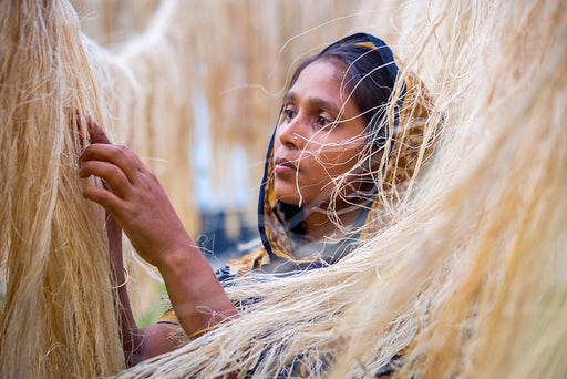 a woman processing the fibers from pineapple leaves