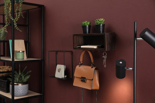 a brown leather handbag hanging on a hook on the wall