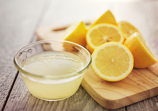a bowl of lemon juice with some fresh lemons