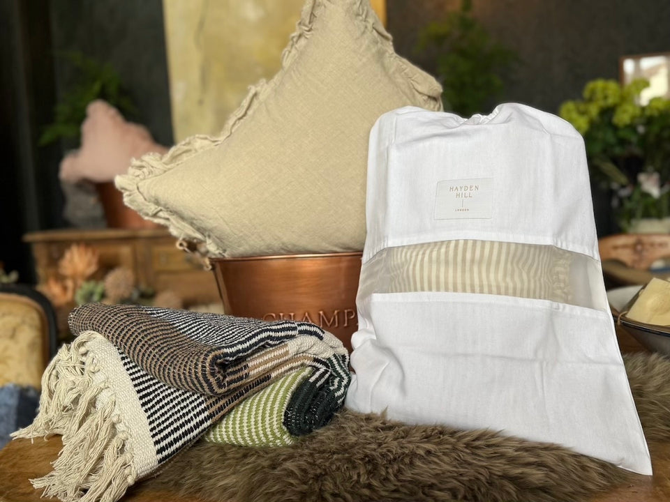 a Hayden Hill dust bag with a see-through organza panel showing striped nightwear inside