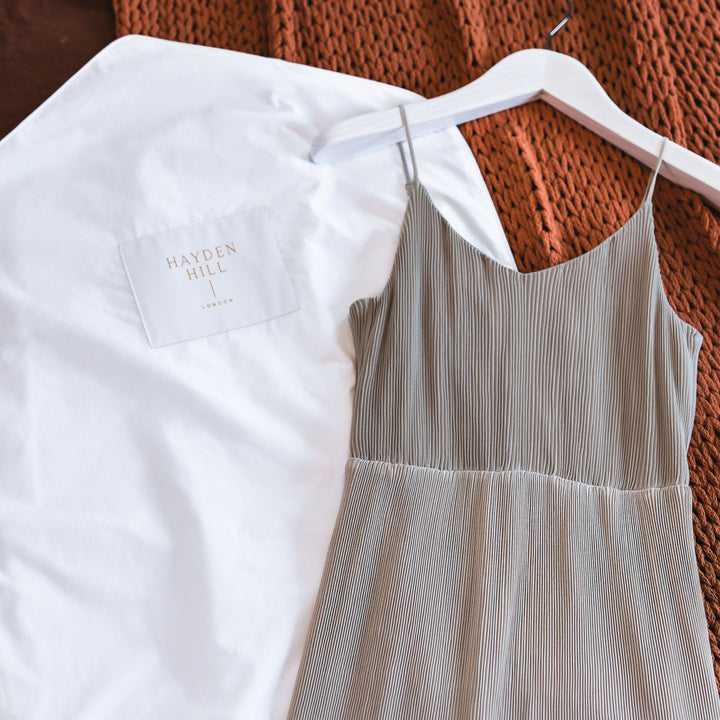 Garment bag and dress on bed