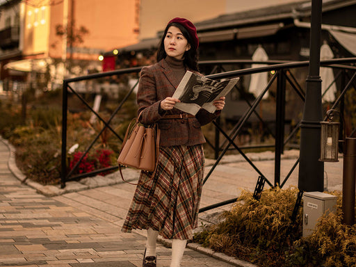 Mai wearing a plaid skirt with a woolen check jacket and dark red beret