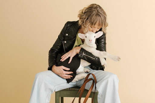 a beautiful image of a woman holding a lamb, styled by Jenna