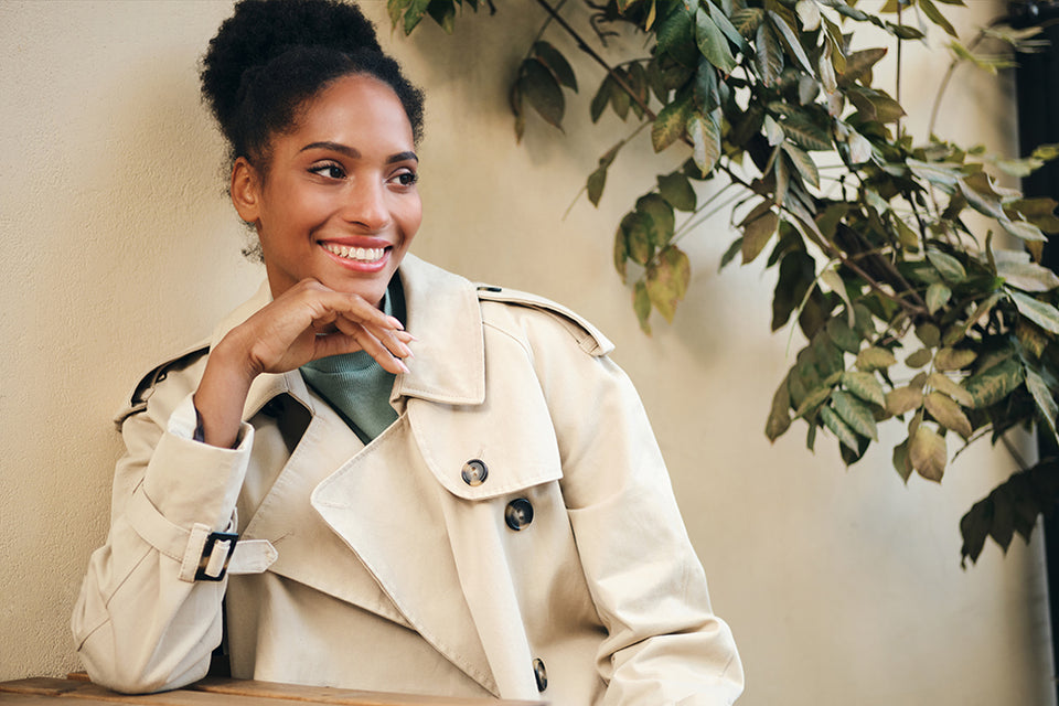 a beautiful woman wearing a stylish écru trench coat 