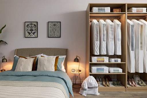 a bedroom with a closet containing shelves and hanging space