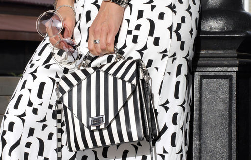 a close up of a black and white skirt teamed with a black and white stripe purse