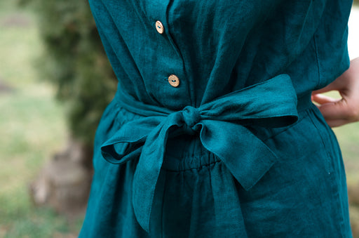 a close up of a dark green linen jumpsuit