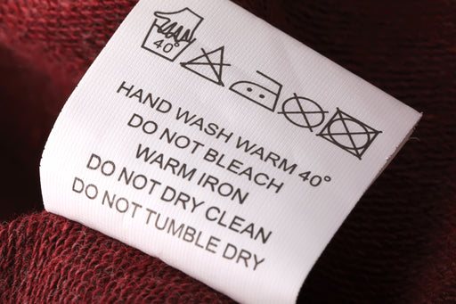 a close up of a hand washing care label on a knitted garment