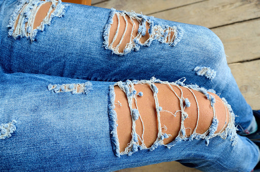 a close up of ripped denim jeans