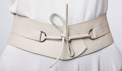 a cream colored leather wide tie belt