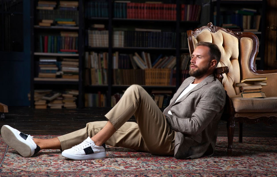 a man in sand colored chinos a linen jacket and sneakers