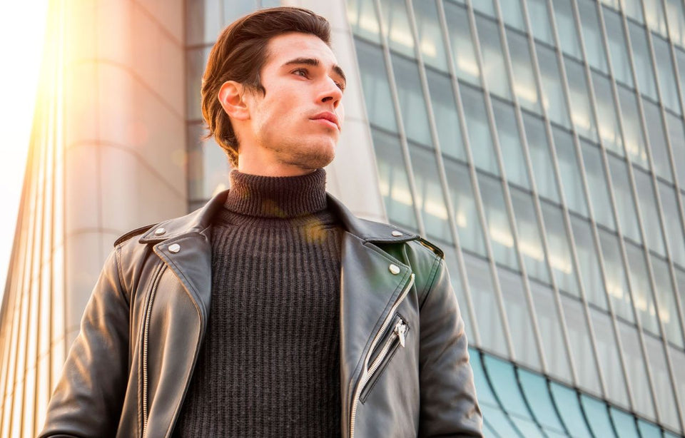 a man wearing a black leather jacket over a ribbed roll neck sweater